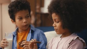 African American girl and boy having lunch, eating cookies and drinking milk - Powered by Shutterstock - Get 15% off with code: PIKWIZARD15