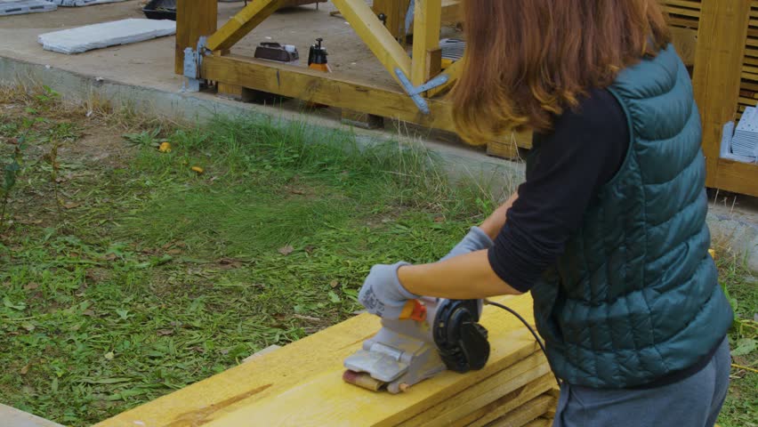 Girl sanding, painting and screwing  wood (no face)