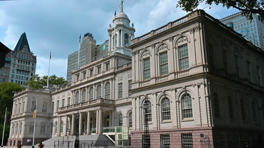 New York, USA, August 15, 2024. Nice static shot of the facade of the city hall seen from three-quarters, people can be seen coming out. Beautiful summer day. Travel destinations.