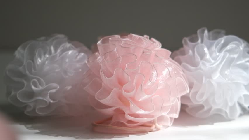 Interlacing flounces of the finest pink silk pleats of textured fabric like a rose flower, light pink fabric bows for decoration stage costume