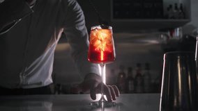 Process of making bright summer cocktail, which includes an essence of orange peel. Bartender twists the peel to give the drink a hint of citrus freshness - Powered by Shutterstock - Get 15% off with code: PIKWIZARD15