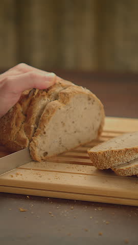 A Deliciously Freshly Baked Bread Placed on a Wooden Cutting Board with a Knife Resting Near It