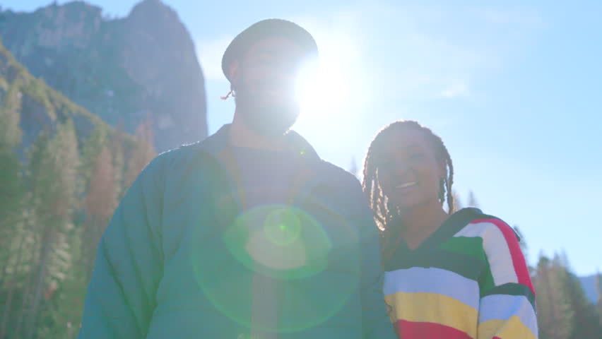 Joyful african american couple stands together in the breathtaking expanse of Yosemite National Park, surrounded by stunning natural scenery and a vibrant sense of adventure, California, USA