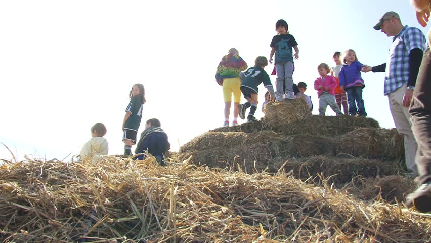 PORTLAND, OREGON - CIRCA 2012: Kids playing on haystacks jump off and laugh on