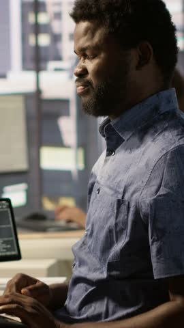 Vertical video System administrator in pain, suffering muscle sprain while developing machine learning APIs. Man feeling backache from sitting at desk all day while training predictive models