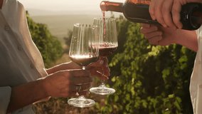Couple dating in nature, drinking wine in vineyards, enjoying romantic date during grapes harvest season. Male hand pouring red wine into glass at sunset. Family weekend together - Powered by Shutterstock - Get 15% off with code: PIKWIZARD15