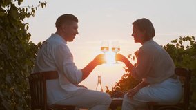 Couple dating in nature at sunset, cheering drinking wine in vineyards, enjoying romantic date during grapes harvest season. Family weekend together, anniversary celebration - Powered by Shutterstock - Get 15% off with code: PIKWIZARD15