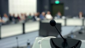 Press conference at round table. Speaker man CEO press conference forum seminar. Group of multiracial colleagues listening. Closeup of hands. Businessman speaking microphone discussion board meeting - Powered by Shutterstock - Get 15% off with code: PIKWIZARD15