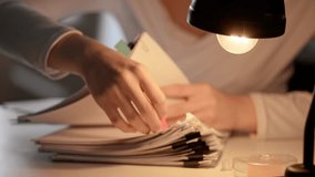 Workaholic woman at office desk searching through stack of paper documents with binder clips and puts colorful tape stickers. Bureaucracy business concept. - Powered by Shutterstock - Get 15% off with code: PIKWIZARD15