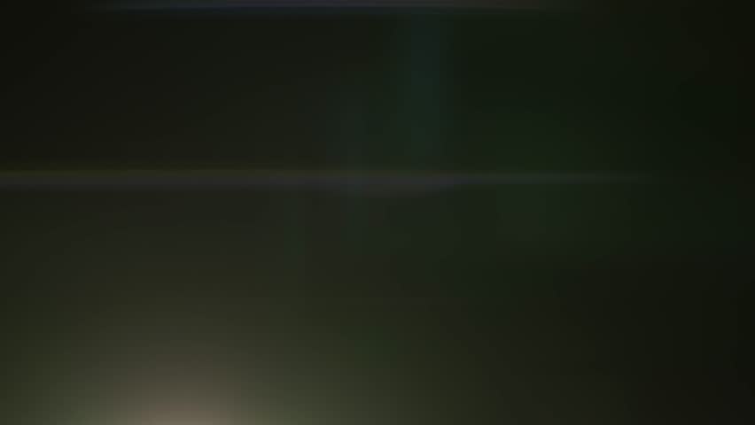A cinematic anamorphic lens flare crosses a dark background with glowing light reflections and abstract streaks. This dynamic visual effect enhances scenes with a professional and atmospheric touch