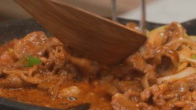 Cooking stir-fried pork with vegetables using a wooden spatula - Powered by Shutterstock - Get 15% off with code: PIKWIZARD15