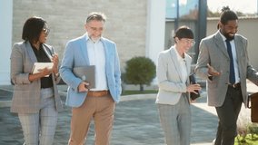 Cheerful multiracial group of business people exiting an office building and communicating while leaving work - Powered by Shutterstock - Get 15% off with code: PIKWIZARD15