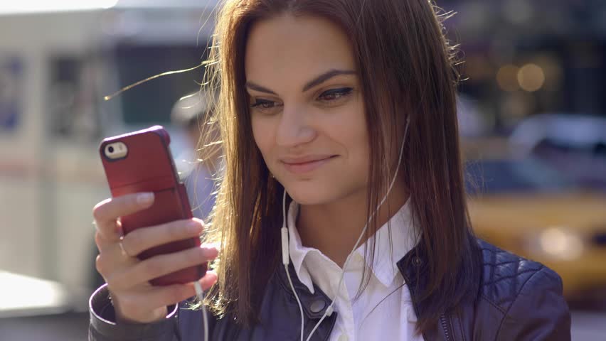 Smart Phone Capturing Her Attention as a Woman Moves through the Streets