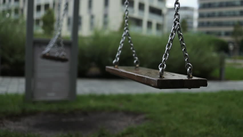 Empty playground after rain. Swing got wet in raindrops. Summer or spring rainy day. No people. No children. High quality FullHD footage