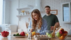 House woman chopping fresh vegetables in kitchen countertop closeup. Smiling husband closing eyes beloved wife. Laughing lady fighting with man playfully. Romantic pair cooking together feeling love - Powered by Shutterstock - Get 15% off with code: PIKWIZARD15