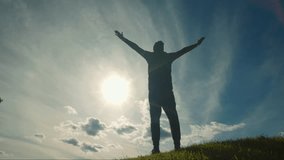 The silhouette of a man stands tall with hands raised under a radiant sky. The scene reflects feelings of achievement, hope, and connection with the natural world. - Powered by Shutterstock - Get 15% off with code: PIKWIZARD15