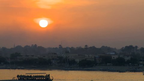 Sunset over Nile river reflecting a golden sky Luxor in Egypt. 