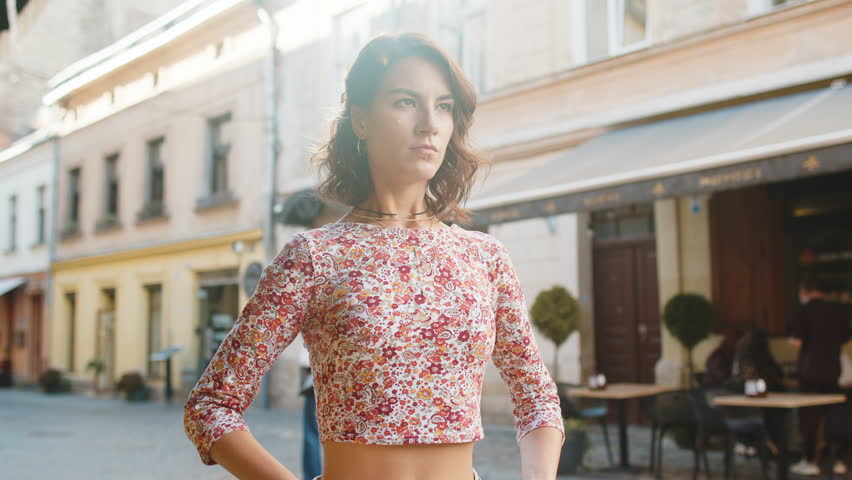 Portrait of Caucasian young woman taking a deep breath of fresh air, relaxing, taking a break, resting, meditating, calm down outdoors. Girl enjoying happy day in urban city street. Town lifestyles