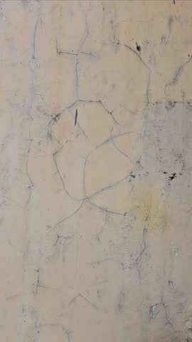 The old walls, due to exposure to rain and heat, have become damaged, the yellow paint has peeled off.