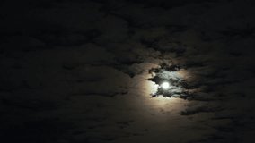 Multicolored halo, moon shining on dark sky. Super moon in clouds. Timelapse. Background for design.  - Powered by Shutterstock - Get 15% off with code: PIKWIZARD15