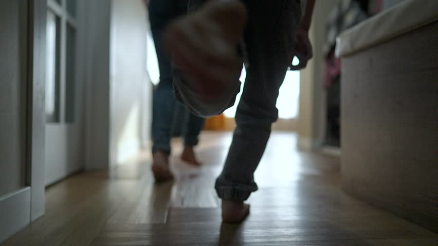 Children run barefoot through house. Joyful kids play and run from room to room. Active children enjoying playful time indoors. Family lifestyle cozy house. Children run around house with excitement.