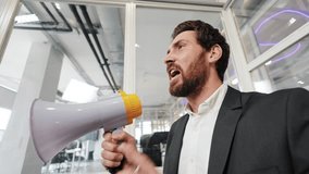 Businessman in suit standing in office hallway speaking into megaphone, making announcements, sharing news, and communicating information to employees. - Powered by Shutterstock - Get 15% off with code: PIKWIZARD15