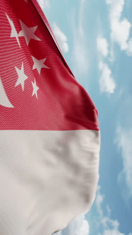 Wavy flag of Singapore blowing in the wind in slow motion. Waving official Singaporean flag team symbol abstract vertical background. Blue sky with clouds. World countries flying flags concept