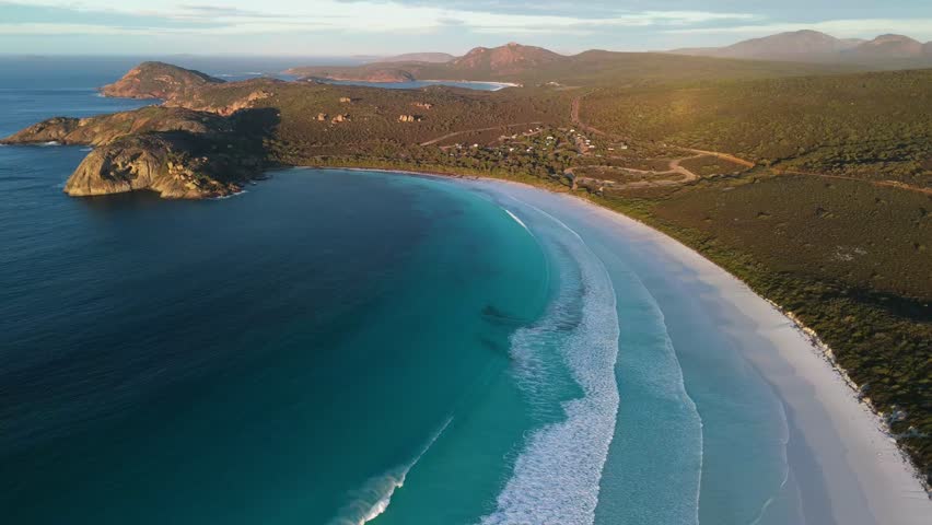 Waves rolling into Lucky Bay, Esperance with mountains in the background of Cape Le Grand National Park