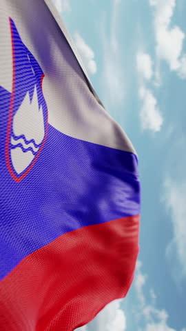 Wavy flag of Slovenia blowing in the wind in slow motion. Waving official Slovenian flag team symbol abstract vertical background. Blue sky with clouds. World countries flying flags concept