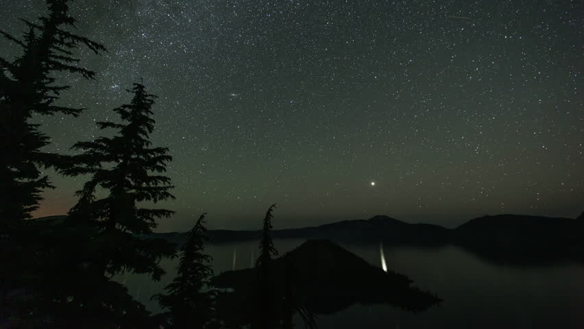 Starry skies at night over Crater Lake and Wizard Island