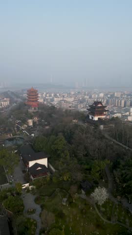 Aerial view of historic pagoda amidst urban skyline and greenery, Wuhan, China.
