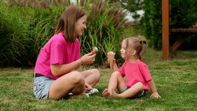 mom and daughter eat ice cream in the summer on the green lawn and enjoy having fun and weekends together, a happy family on vacation, a mother with a small child walking in the summer - Powered by Shutterstock - Get 15% off with code: PIKWIZARD15
