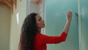 Caucasian girl student Hispanic woman Latina American female in university college auditorium writing chalk mathematical calculations formula on board black board in classroom study education school - Powered by Shutterstock - Get 15% off with code: PIKWIZARD15