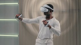 Gaming addict modern use African American ethnic futuristic man gamer male guy play virtual game wearing vr glasses helmet holding controllers playing video game futurism cyberspace indoor metaverse - Powered by Shutterstock - Get 15% off with code: PIKWIZARD15