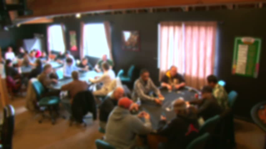 Soft focus, unrecognizable people in poker club gambling at poker card tables,