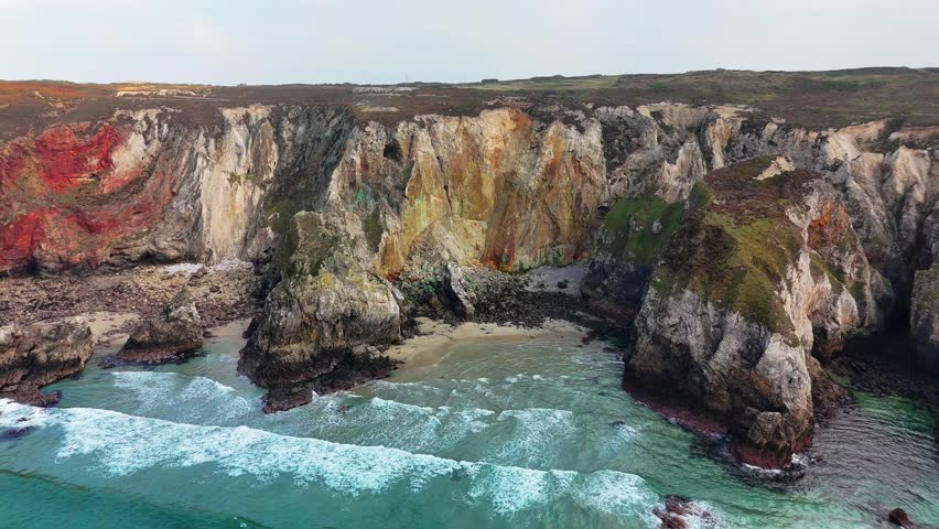 An aerial view of rocky cliffs overlooking sea at St Agnes Heritage Coast in Cornwall, Perranporth, England