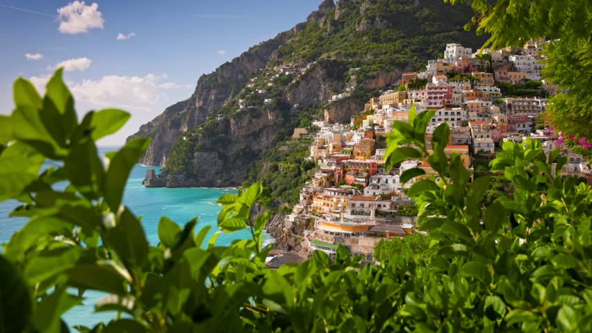 Stunning views of Positano with vibrant houses nestled on the cliffs, overlooking sparkling Mediterranean Sea. Positano village on the Amalfi Coast, Italy. Gimbal shot, 4K