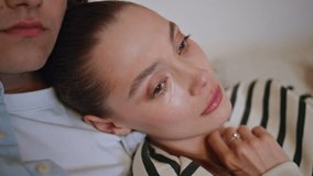 Sad wife watching melodrama with tears on eyes leaning on husband shoulder closeup. Caring man calming emotional woman at evening home couch. Romantic spouses enjoy television movie hugging on sofa. - Powered by Shutterstock - Get 15% off with code: PIKWIZARD15