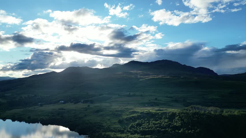 downward panning shot of the sunny hills on loch tay