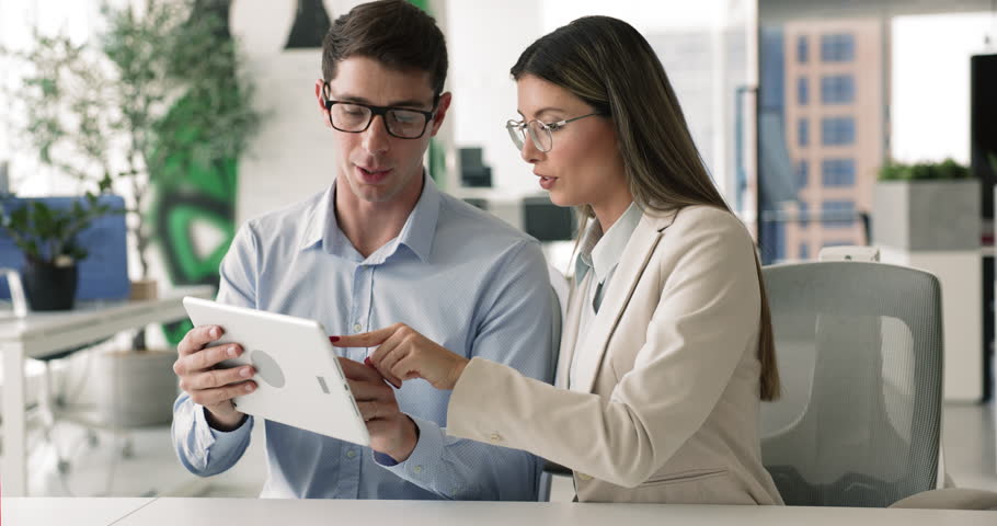 Client and sales manager met in office using tablet, review contract terms, company services or product features, benefits, planning marketing campaign, strategy. Briefing, brainstorm, joint project