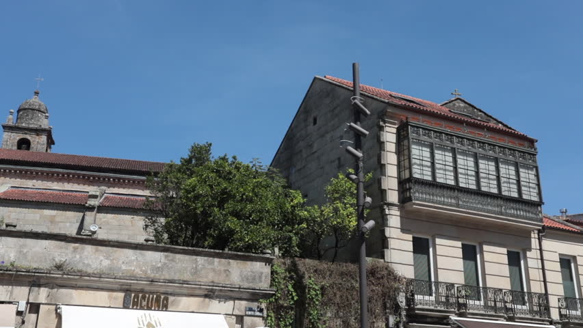 Historic building in Pontevedra, Spain, with greenery and clear blue skies captured during the day