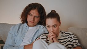 Girlfriend frightened scary movie sitting in boyfriend hug at comfortable couch closeup. Young couple watching television horror film at domestic evening. Worried woman hiding face in palms scared TV. - Powered by Shutterstock - Get 15% off with code: PIKWIZARD15