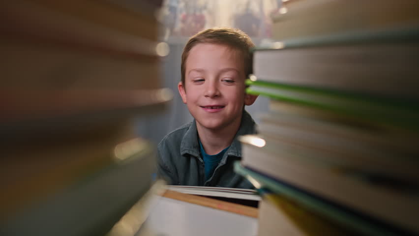 A schoolboy reads a book and plays with a dog that licks his cheek. happy smiling child with pet, animal love lifestyle concept. High quality 4k footage