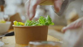A chef carefully places a lid on a container filled with a colorful, freshly prepared salad, demonstrating culinary expertise and attention to detail in a bright kitchen - Powered by Shutterstock - Get 15% off with code: PIKWIZARD15