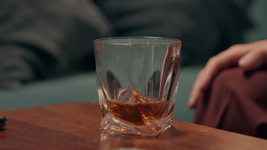 Depressed Caucasian drunk male man addict guy drinking alcohol glass whiskey holding cigar smoking mental health problems alcoholism unhealthy lifestyle addiction bad habit at home room weekend party