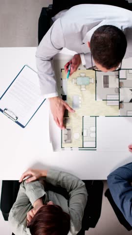 Real Estate Consultant Showing Apartment Blueprint To Miniature