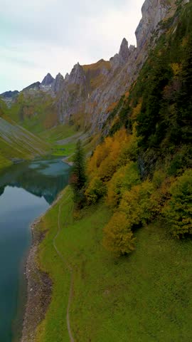 Experience the tranquil allure of Falensee lake, surrounded by majestic Alps in Appenzell Innerrhoden. Autumn foliage paints the landscape, inviting peaceful exploration along the shores. Switzerland