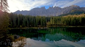 Experience the tranquil allure of a pristine Alpine lake illuminated by the soft light of dawn, framed by stunning mountain peaks and lush forests, Karersee lake Dolomites, Italy, lake Carezza - Powered by Shutterstock - Get 15% off with code: PIKWIZARD15