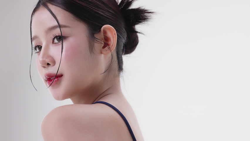 Slow motion of beautiful young Asian girl with k-beauty make up style on isolated white background. Healthy and fresh skin woman footage for cosmetic, skin care commercial advertising.
