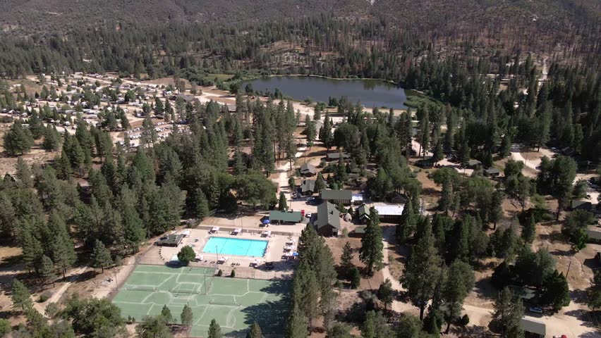 Drone shot over the Sequoia National Forest looking down at a campground and then tilting up toward a mountainside.